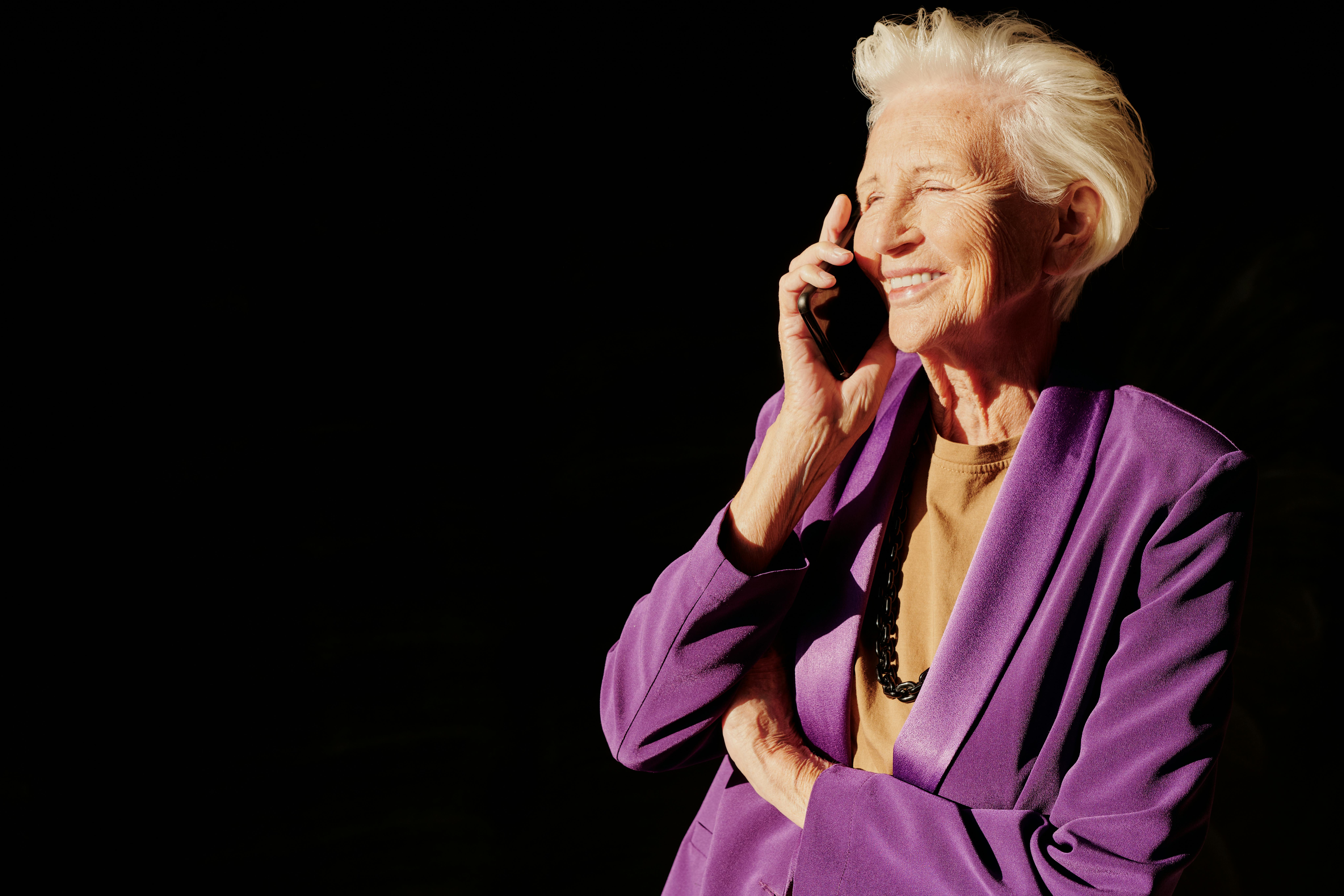 A senior woman smiling warmly during a phone call